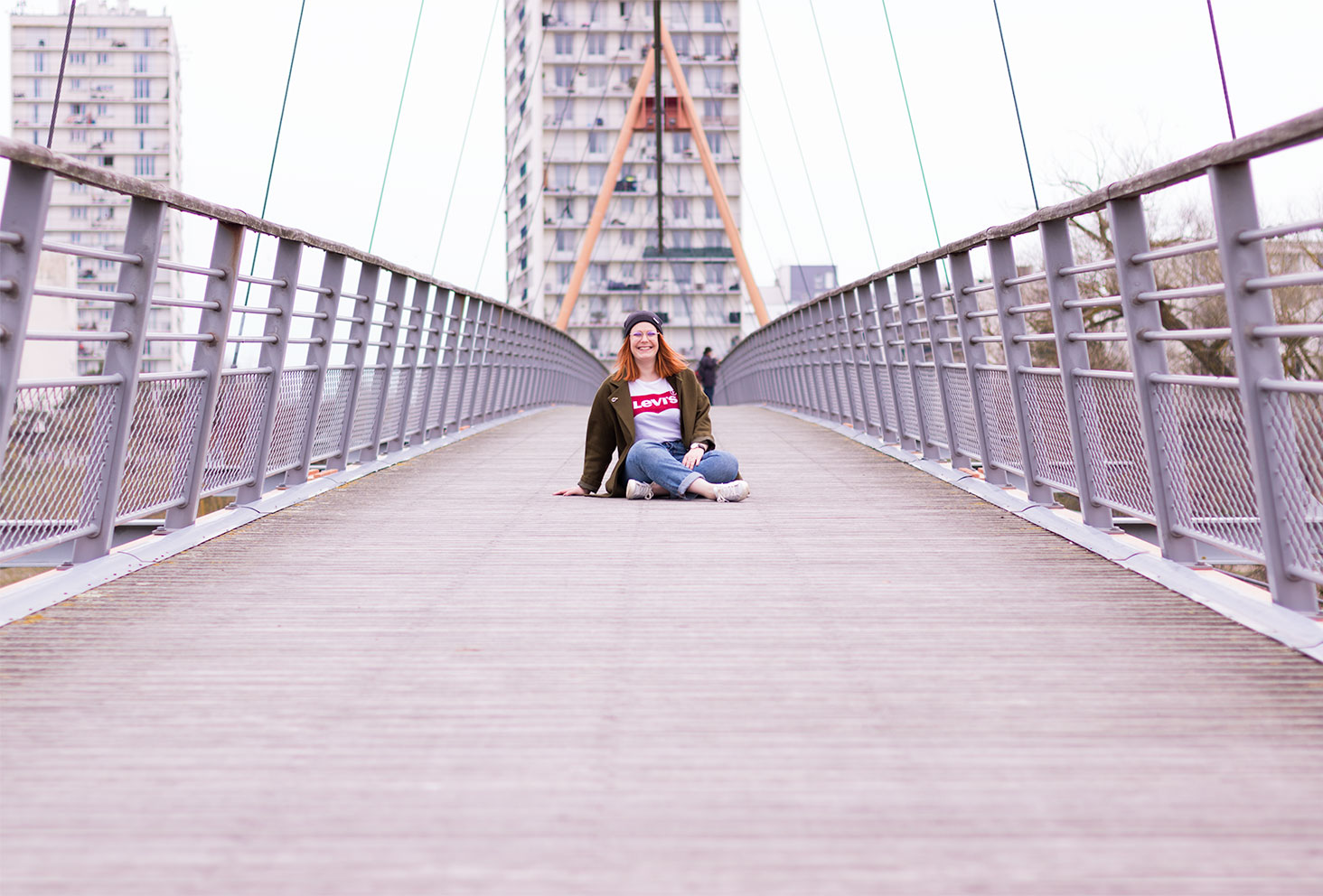 Assise sur un pont suspendu en bois et en métal en street style