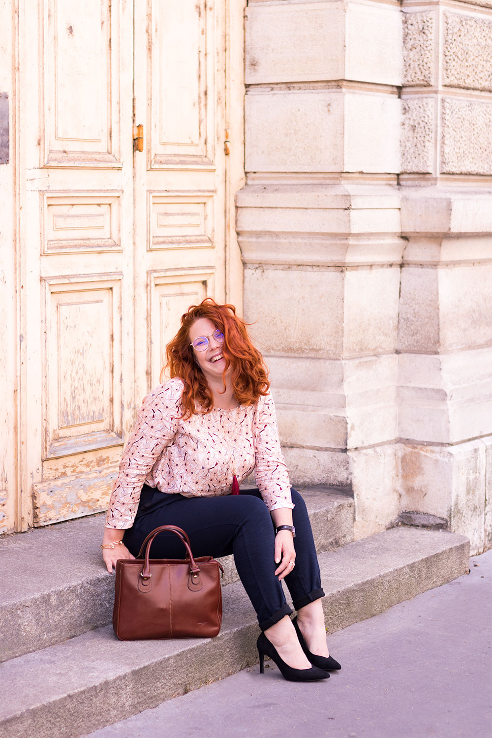 Assise sur les marches en bétons le long du grand théâtre de Tours, en pantalon cigarette bleu et blouse rose La Morue, pour la rentrée