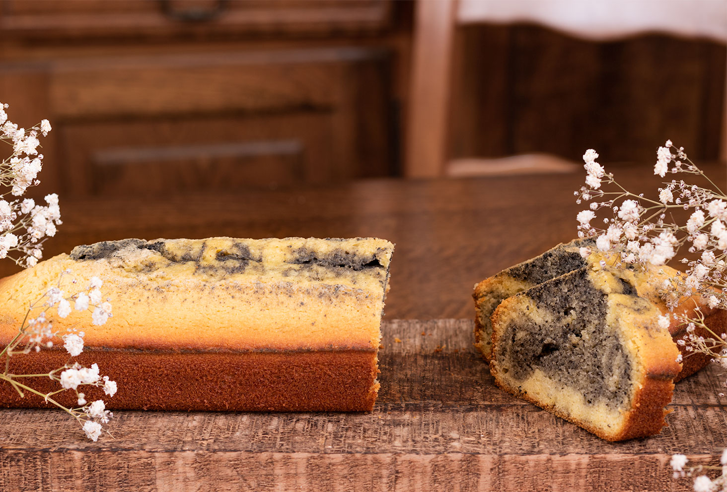La texture du cake marbré au sésame noir d'une part coupée au milieu du gâteau, sur une planche et une table en bois