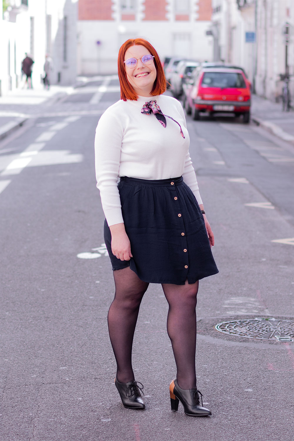 Look du sourire en entier dans la rue, jupe bleue fluide, pull blanc à col cheminée SheIn et bottine noire à talons hauts