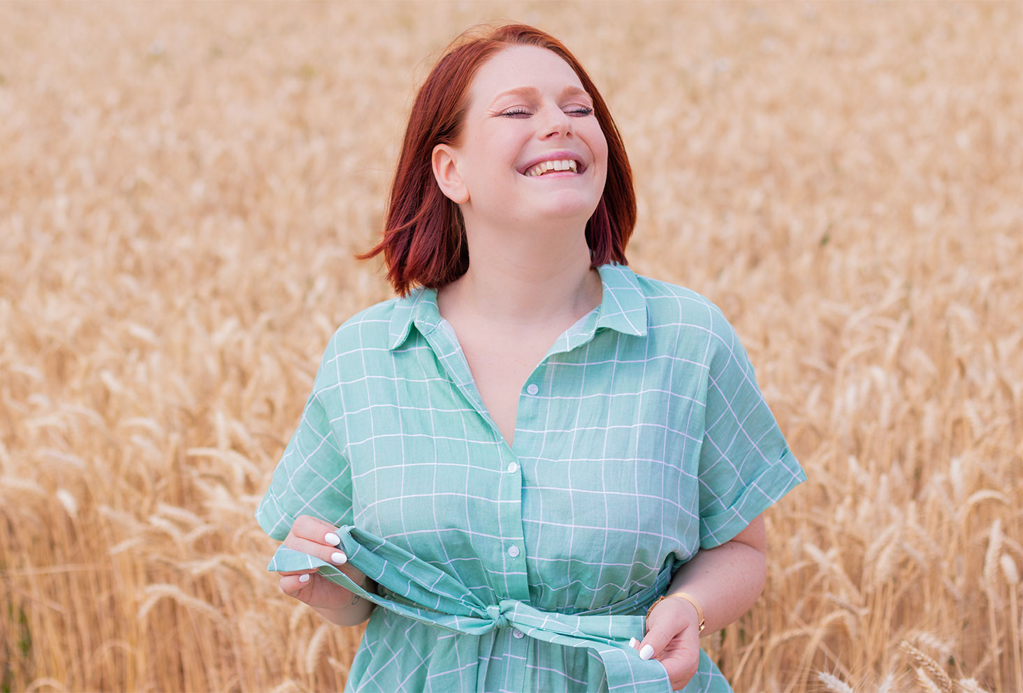 Zoom sur le haut de la robe chemise Shein au milieu des champs de blé avec le sourire
