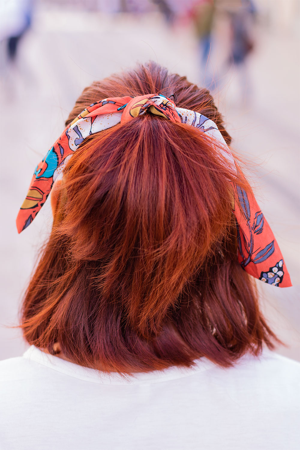 Zoom de dos sur le headband orange qui tient une demi queue de cheval