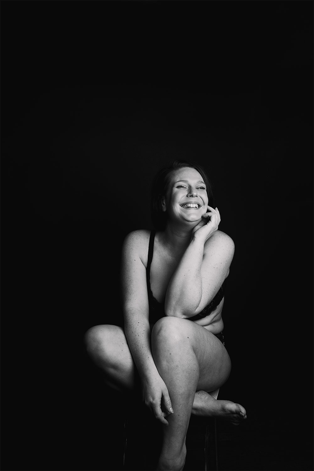 Photo studio en noir et blanc, assise avec le sourire en sous-vêtements Pomm'Poire