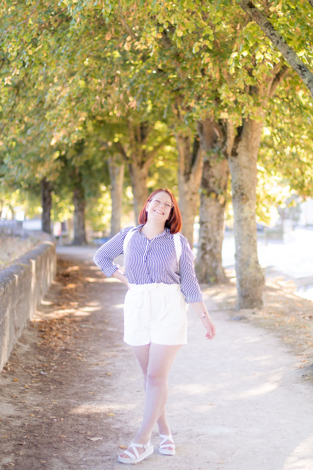 Sur les bords de Loire avec le sourire, le sac sur le dos, en chemise et short blanc