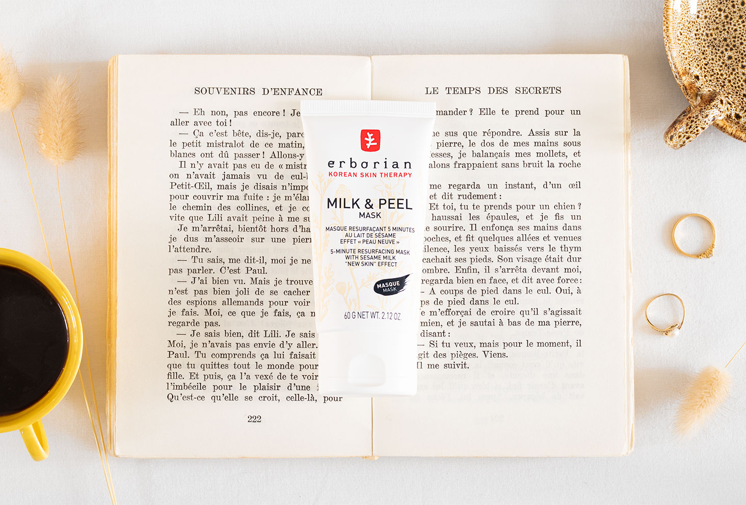 Zoom sur le Milk & Peel Mask de Erborian posé au milieu d'un livre ancien ouvert