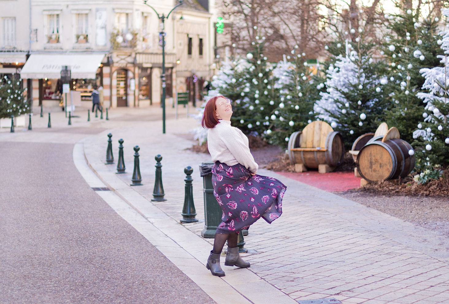Dans les rues d'Amboise devant les décorations de Noël, en jupe qui tourne et pull gris, avec le sourire pour débuter 2021