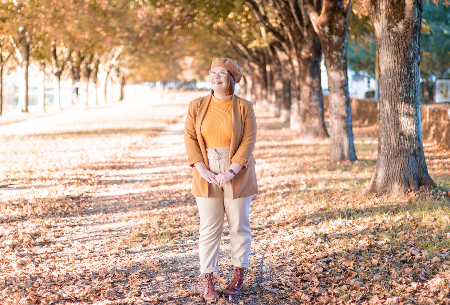 Au milieu des arbres et des feuilles d'automne dans une tenue marron de working girl automnale