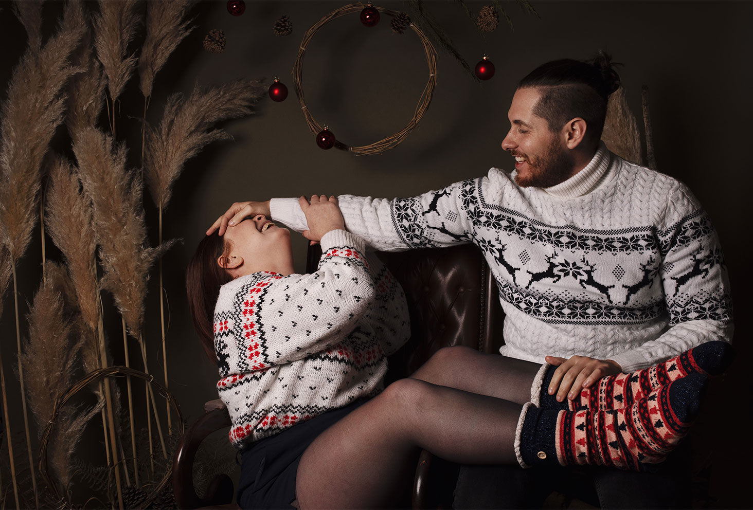 Séance photo de couple en studio avec des pulls de Noël pour les fêtes