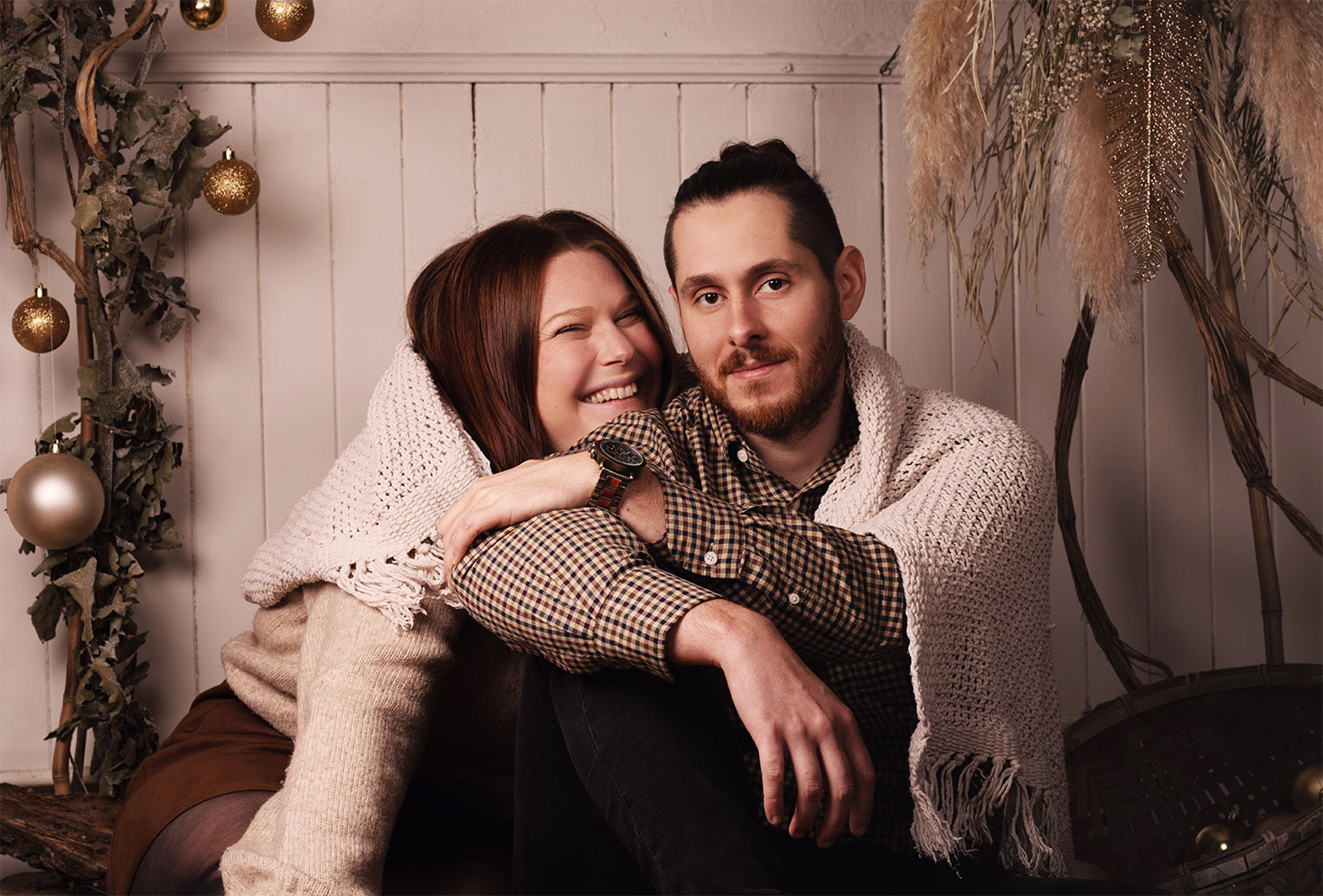 Shooting de Noël en couple dans un studio décoré en bois et doré