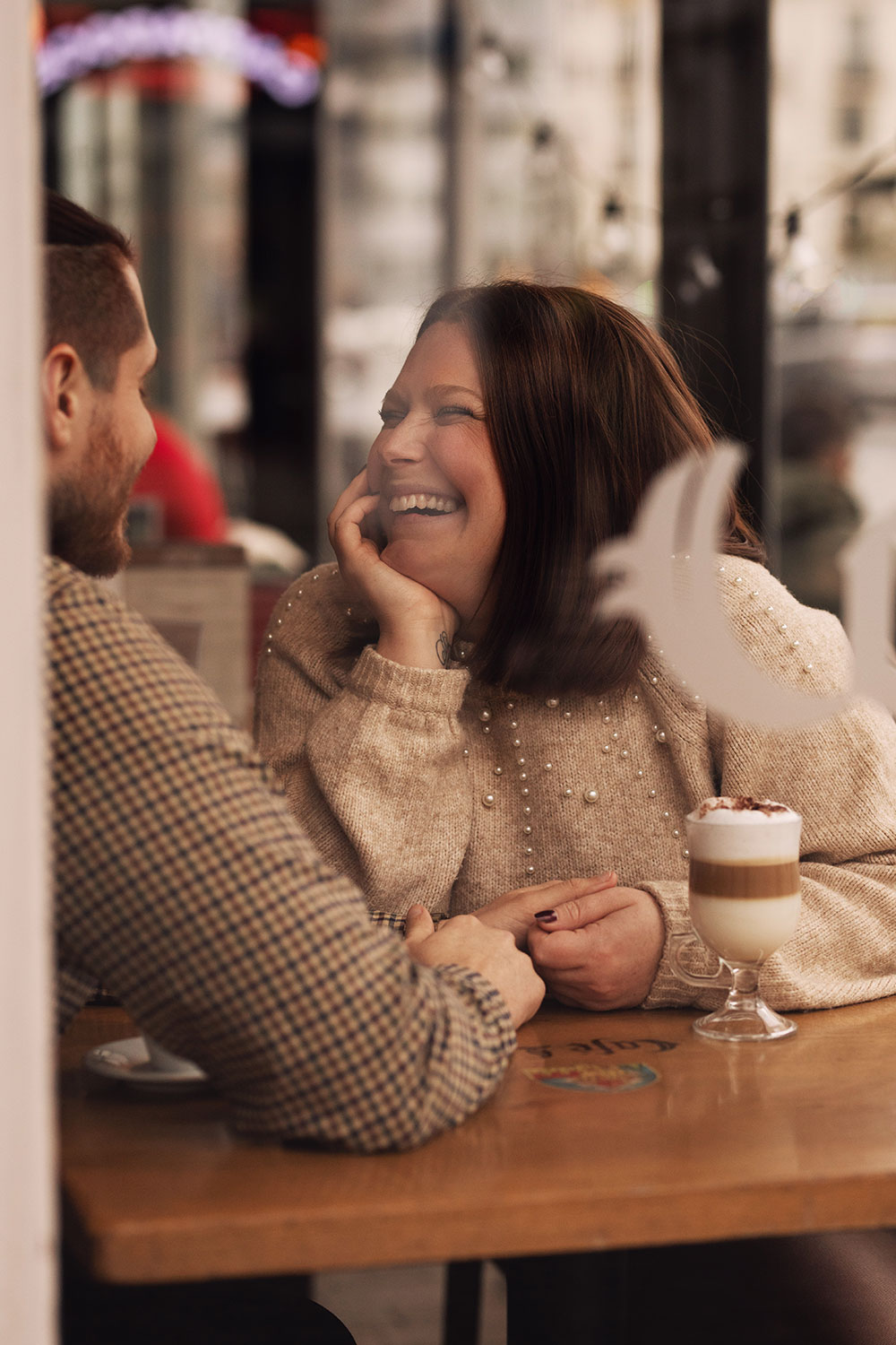 Couple amoureux assis à la table d'un café avec le sourire se tenant les mains