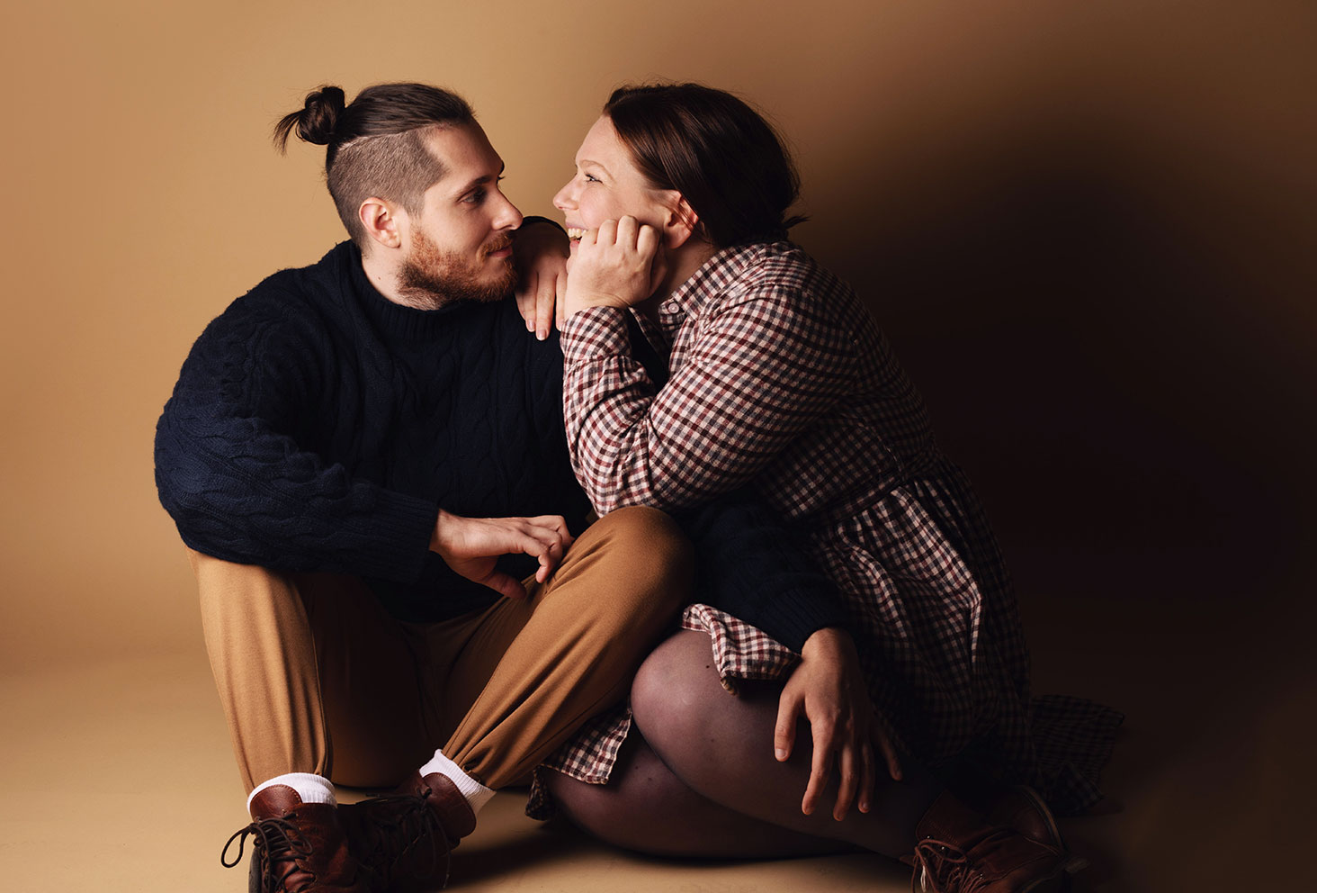 Photo de couple assis au sol dans un studio photo