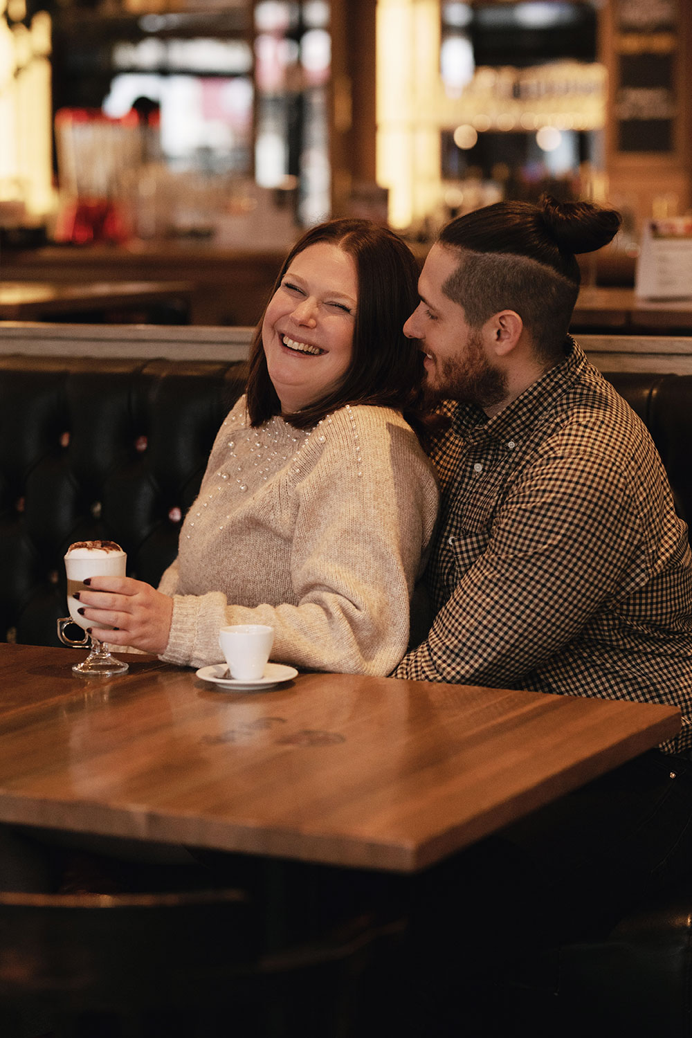 Couple souriant dans un café avec un latte à la main