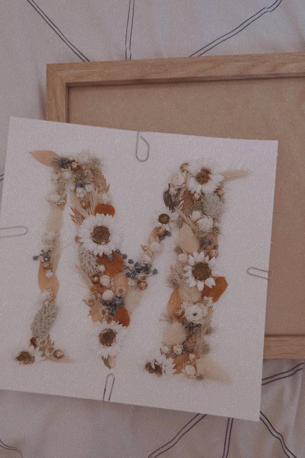 Réalisation d'une lettre en fleurs séchées dans un cadre pour un cadeau de naissance